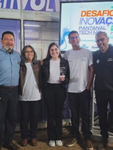 Integrantes do projeto AcroNano e representantes do evento posam com o prêmio conquistado.