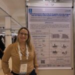 Ana Paula de Araújo Boleti diante do pôster sobre o efeito anti-inflamatório do peptídeo D-18 em células microgliais.