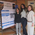 Pesquisadoras diante do pôster sobre o mecanismo de ação antimicrobiana do peptídeo D-18.