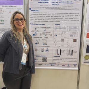 Khristiane Santos diante do pôster sobre nanopartículas contendo extrato da casca da amêndoa de baru.