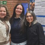 Larissa Lorrayne Alves da Silva e pesquisadoras diante do pôster sobre bioplásticos produzidos com bocaiuva.