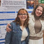 Maria Beatriz Pereira e Ana Cristina diante do pôster sobre síntese verde de nanopartículas de prata utilizando extrato de jatobá.
