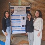 Vitória Silva e pesquisadoras diante do pôster sobre o peptídeo antimicrobiano GWA-17.